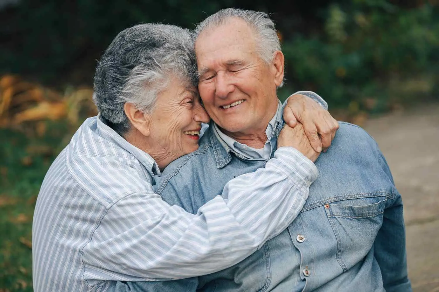 An older couple sharing a hug outdoors